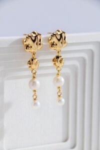 Close-up of hand-hammered gold metal and freshwater pearl details