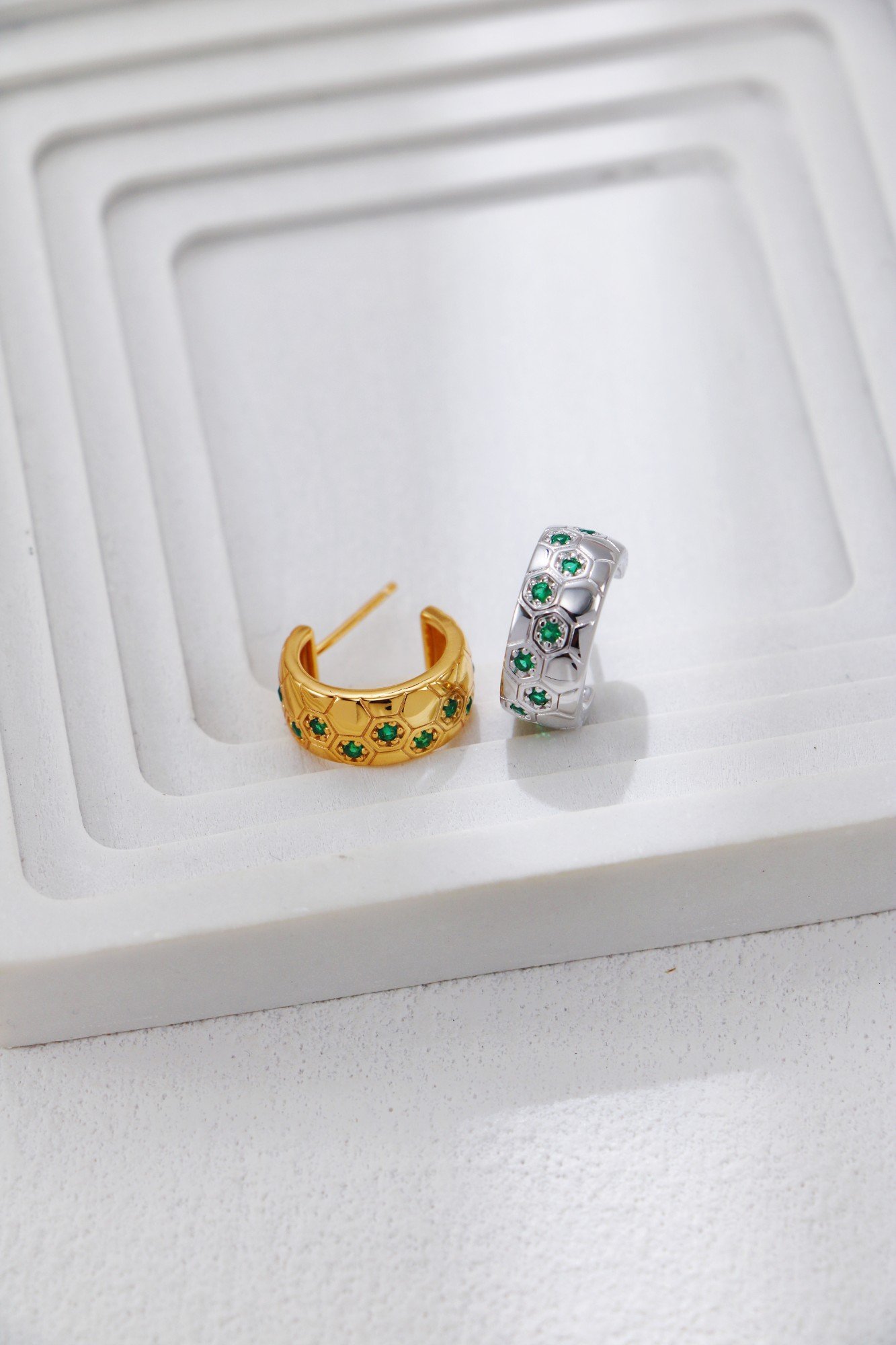 S925 silver and gold hoop earrings with inlaid green zircon on white stepped display