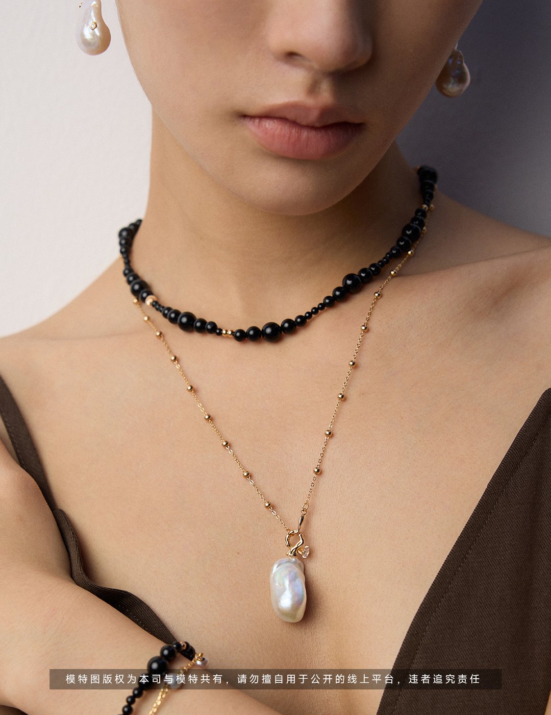 Sterling silver black agate beaded necklace with gold accents on white background
